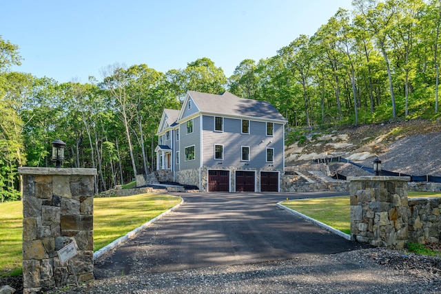 19 Ives Ct, Ridgefield, CT 06877 - view of front facade with an attached garage, driveway, and stone siding