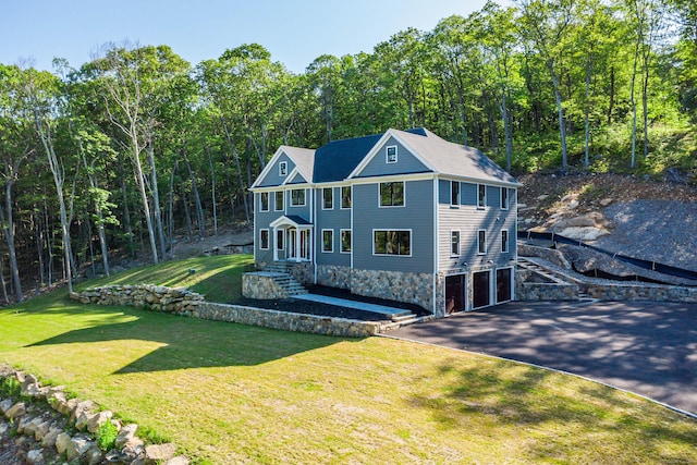 19 Ives Ct, Ridgefield, CT 06877 - view of front of house with an attached garage, driveway, a front lawn, and a forest view