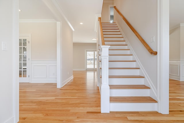 19 Ives Ct, Ridgefield, CT 06877 - stairway featuring crown molding, wood finished floors, a decorative wall, and wainscoting