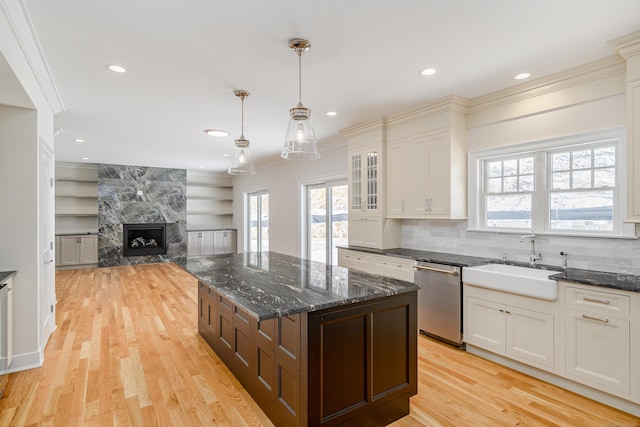 19 Ives Ct, Ridgefield, CT 06877 - kitchen with dishwasher, a fireplace, light wood-style floors, glass insert cabinets, and ornamental molding