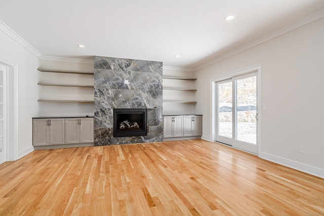 19 Ives Ct, Ridgefield, CT 06877 - unfurnished living room with ornamental molding, wood finished floors, built in shelves, a large fireplace, and recessed lighting