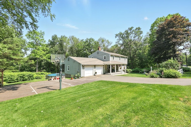 247 Mountain View Rd, Somers, CT 06071 - view of front of house with a front lawn, an attached garage, asphalt driveway, view of wooded area, and covered porch