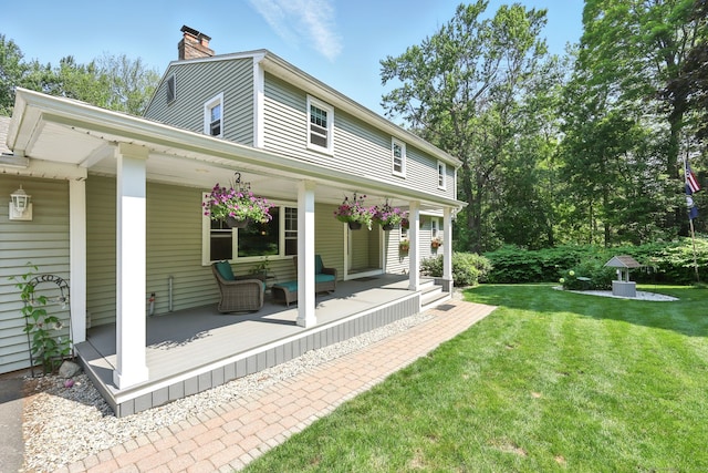 247 Mountain View Rd, Somers, CT 06071 - rear view of house featuring a porch, a lawn, and a chimney