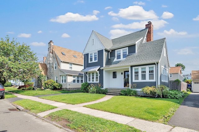 946 Wilcoxson Ave, Stratford, CT 06614 - view of front of house with board and batten siding, a front yard, a shingled roof, and a chimney