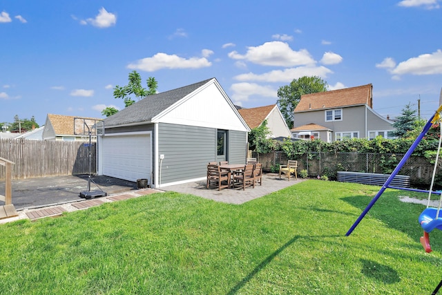 946 Wilcoxson Ave, Stratford, CT 06614 - back of house with a fenced backyard, a patio, an outbuilding, a detached garage, and a shingled roof