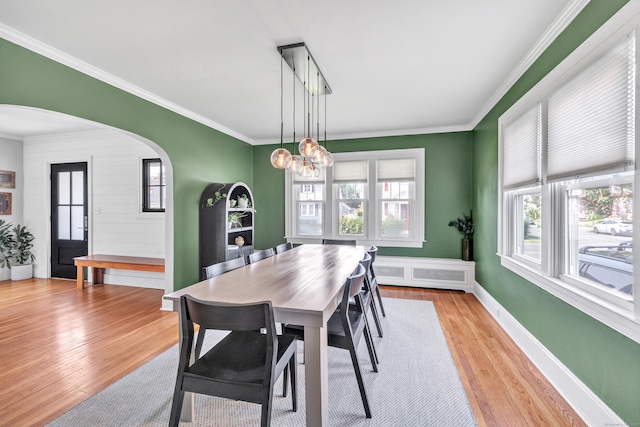 946 Wilcoxson Ave, Stratford, CT 06614 - dining area featuring arched walkways, plenty of natural light, ornamental molding, light wood-style floors, and radiator