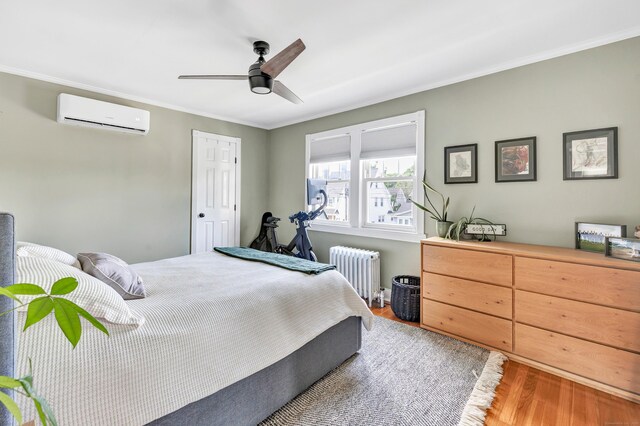 946 Wilcoxson Ave, Stratford, CT 06614 - bedroom with radiator, a wall unit AC, wood finished floors, ornamental molding, and a ceiling fan