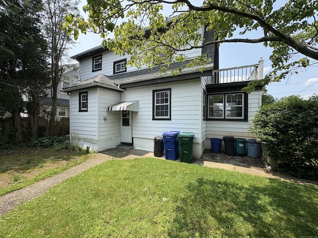 5 Lindsley Pl, Stratford, CT 06615 - rear view of house with a lawn, entry steps, a chimney, and a shingled roof