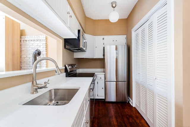 118 Washington St # U304, Norwalk, CT 06854 - kitchen featuring stainless steel appliances, white cabinetry, light countertops, dark wood-type flooring, and pendant lighting