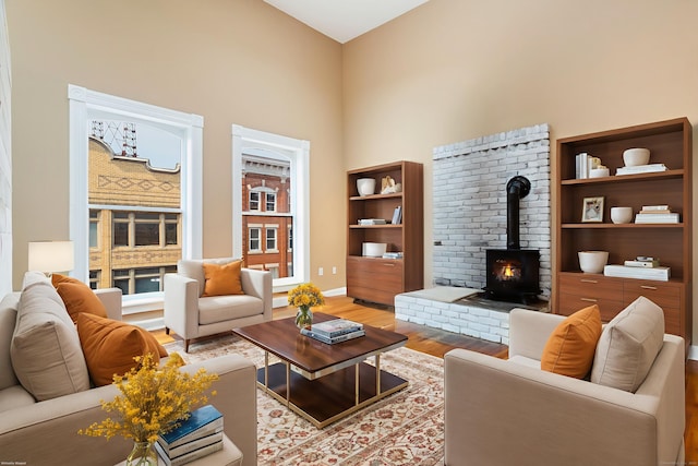 118 Washington St # U304, Norwalk, CT 06854 - living room featuring a wood stove, wood finished floors, and a high ceiling