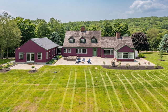 93 Northfield Rd, Litchfield, CT 06759 - back of property with a patio area, a chimney, a yard, an outdoor hangout area, and a forest view