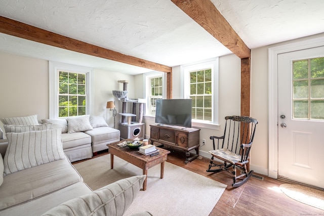 60 Pomperaug Rd, Woodbury, CT 06798 - living area with wood finished floors, beamed ceiling, healthy amount of natural light, and a textured ceiling