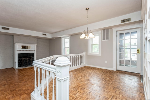 71A Imlay St Unit D2, Hartford, CT 06105 - spare room with a chandelier, a fireplace with flush hearth, and brick wall