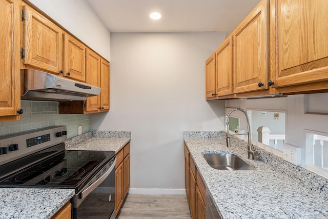 71A Imlay St Unit D2, Hartford, CT 06105 - kitchen with stainless steel range with electric stovetop, under cabinet range hood, light wood-style flooring, backsplash, and light stone countertops