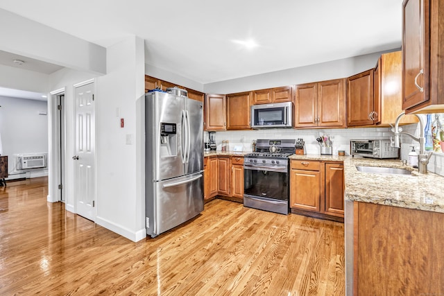 20 Oakland Ave Apt 3B, Danbury, CT 06810 - kitchen featuring stainless steel appliances, brown cabinets, light wood-type flooring, and a wall mounted AC