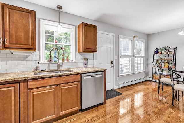 20 Oakland Ave Apt 3B, Danbury, CT 06810 - kitchen with stainless steel dishwasher, baseboard heating, brown cabinetry, light wood-style flooring, and tasteful backsplash