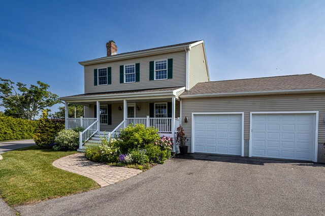 509 Main St Unit 6, Old Saybrook, CT 06475 - view of front of home with asphalt driveway, a chimney, a garage, covered porch, and a front yard