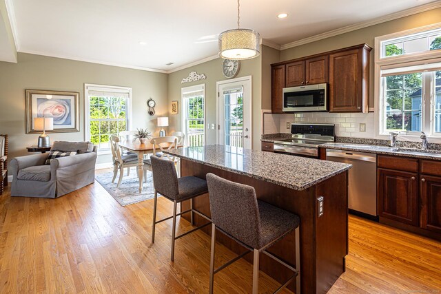 509 Main St Unit 6, Old Saybrook, CT 06475 - kitchen with appliances with stainless steel finishes, a kitchen island, light wood finished floors, healthy amount of natural light, and recessed lighting