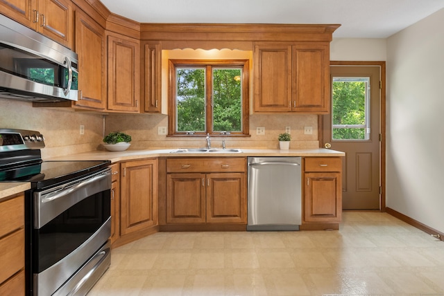 84 Bourbon St, South Windsor, CT 06074 - kitchen featuring stainless steel appliances, brown cabinetry, and tasteful backsplash