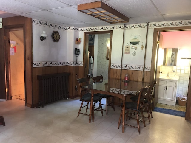 38 Upland Rd, Winchester, CT 06098 - dining room with a paneled ceiling, light floors, a wainscoted wall, wooden walls, and radiator heating unit