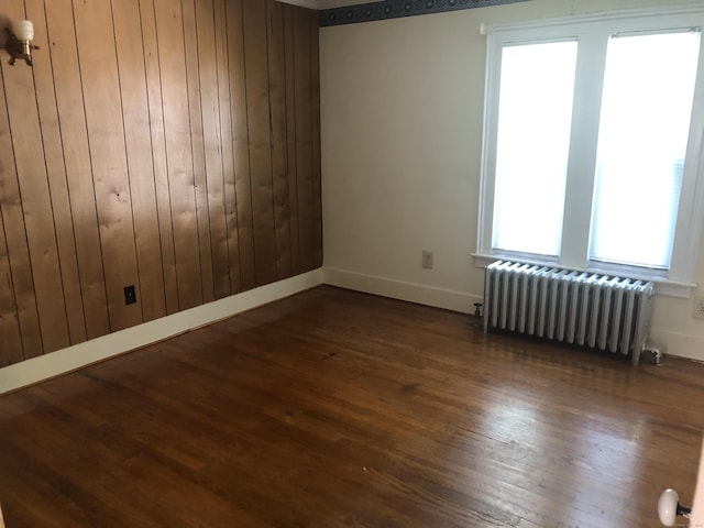 38 Upland Rd, Winchester, CT 06098 - empty room with radiator, dark wood-style flooring, and wooden walls