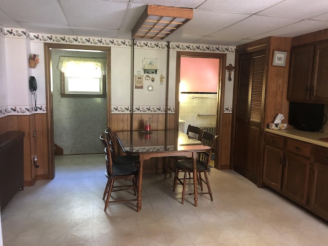 38 Upland Rd, Winchester, CT 06098 - dining space featuring a paneled ceiling, light floors, a wainscoted wall, wood walls, and wallpapered walls