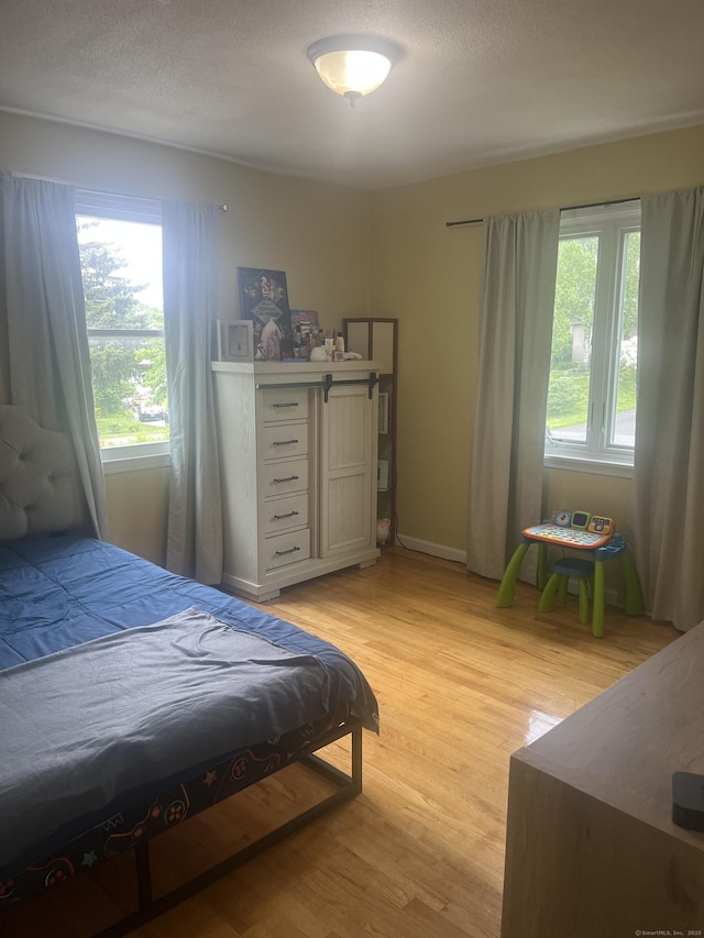 62 Haddad Rd, Waterbury, CT 06708 - bedroom with light wood-style flooring and a textured ceiling