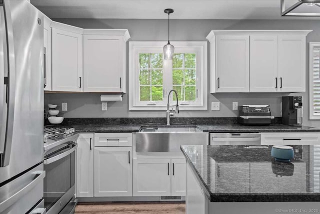 379 Tripp Hollow Rd, Brooklyn, CT 06234 - kitchen with stainless steel appliances, white cabinetry, pendant lighting, dark stone countertops, and light wood-style flooring