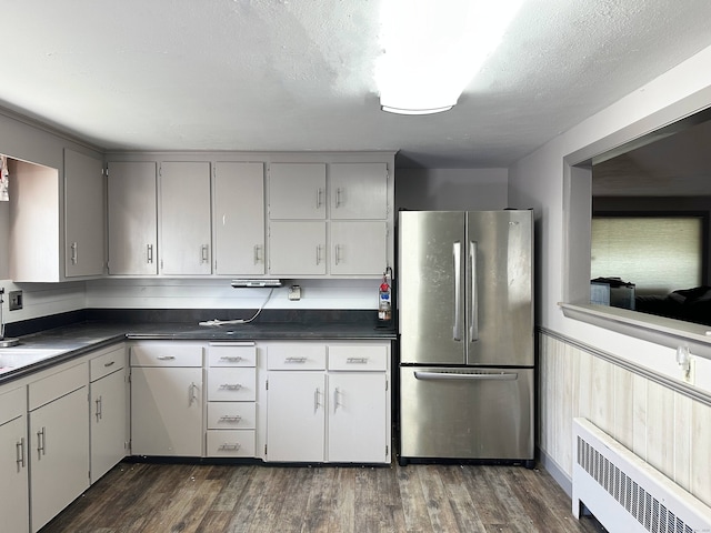 70 Cedar Ridge Rd, Newington, CT 06111 - kitchen with freestanding refrigerator, radiator, dark countertops, and dark wood-style flooring
