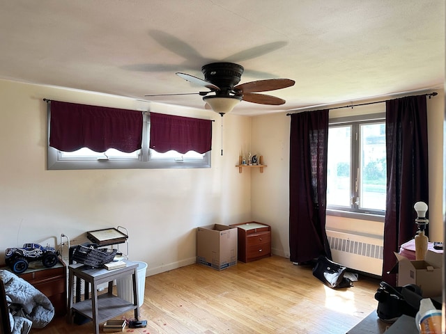 70 Cedar Ridge Rd, Newington, CT 06111 - miscellaneous room featuring radiator heating unit, light wood-type flooring, and a ceiling fan