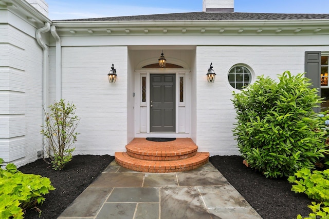 2787 Redding Rd, Fairfield, CT 06824 - view of exterior entry with brick siding, a chimney, and roof with shingles