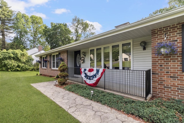 29 Birchwood Dr, Killingly, CT 06241 - view of front of home with brick siding, a front lawn, covered porch, and a chimney