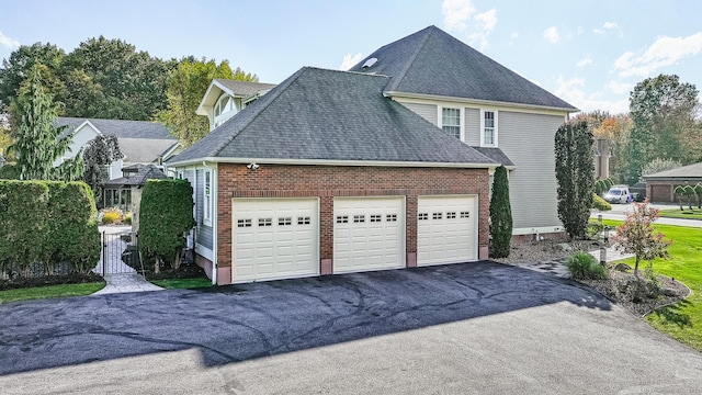 10 Amato Dr, Wethersfield, CT 06109 - view of side of home featuring driveway, an attached garage, a shingled roof, and brick siding
