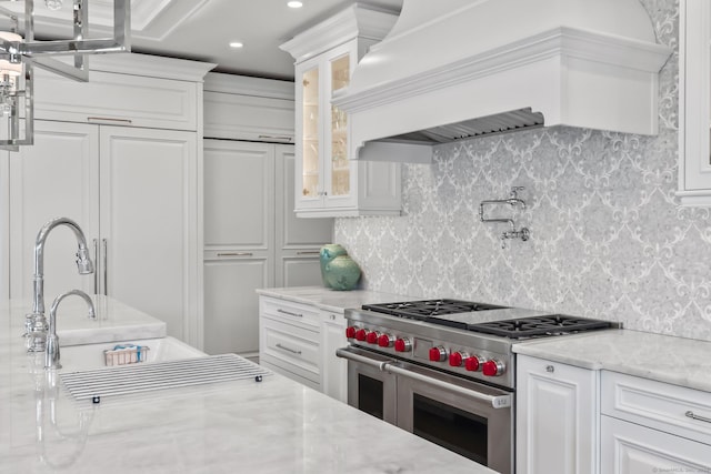 10 Amato Dr, Wethersfield, CT 06109 - kitchen with double oven range, premium range hood, glass insert cabinets, tasteful backsplash, and recessed lighting