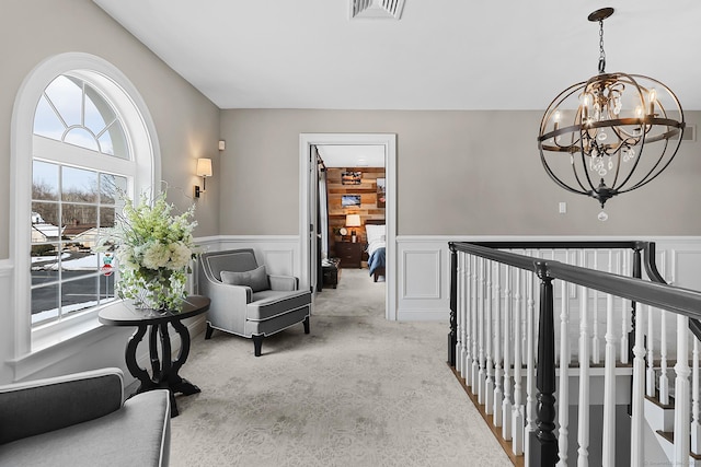 10 Amato Dr, Wethersfield, CT 06109 - corridor with wainscoting, a chandelier, light colored carpet, a decorative wall, and an upstairs landing