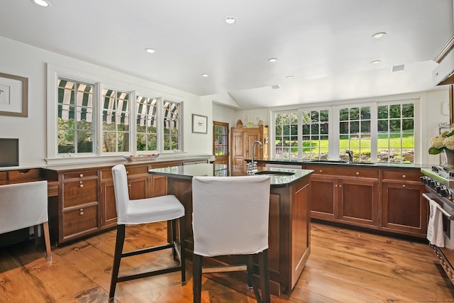216 Hillspoint Rd, Westport, CT 06880 - kitchen with a kitchen island with sink, stainless steel gas range oven, light wood-type flooring, recessed lighting, and a breakfast bar