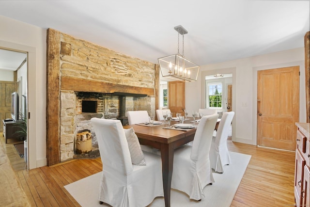 216 Hillspoint Rd, Westport, CT 06880 - dining room with light wood-style flooring, a fireplace, and a chandelier