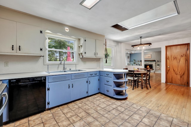 98 Torrington Ave, Canton, CT 06019 - kitchen with black dishwasher, open shelves, blue cabinetry, light countertops, and a peninsula