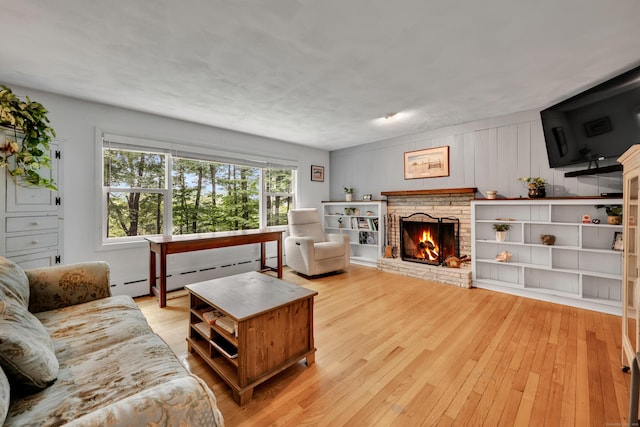 98 Torrington Ave, Canton, CT 06019 - living room with baseboard heating, light wood-style floors, and a brick fireplace