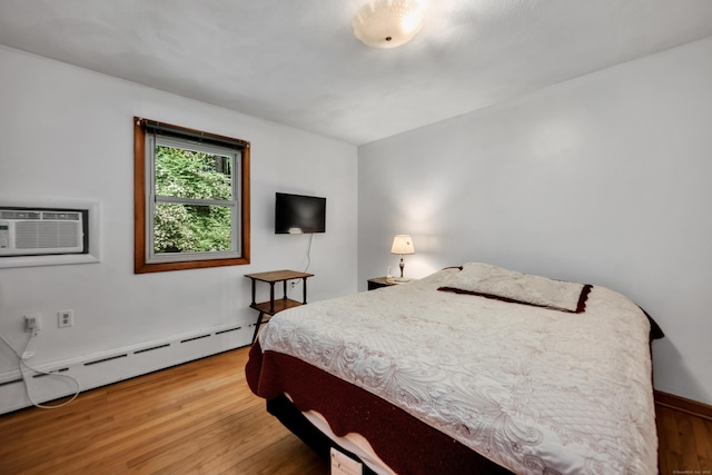 98 Torrington Ave, Canton, CT 06019 - bedroom with a baseboard heating unit, an AC wall unit, and wood finished floors