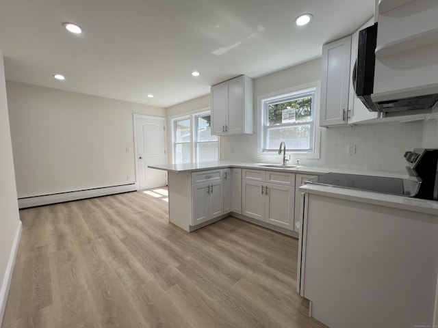 52 Sylvan St, Avon, CT 06001 - kitchen with a baseboard radiator, a peninsula, stainless steel electric range oven, tasteful backsplash, and recessed lighting
