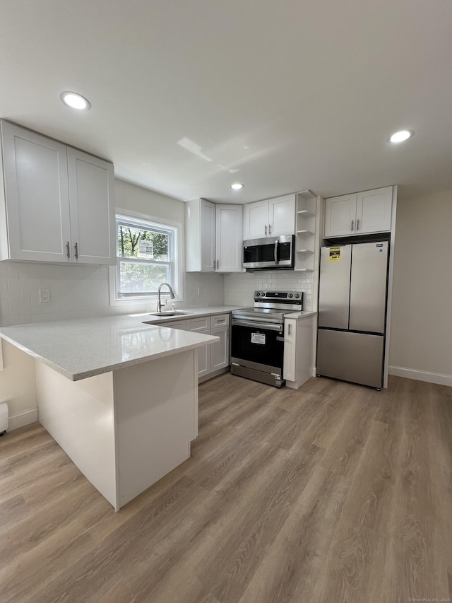 52 Sylvan St, Avon, CT 06001 - kitchen featuring appliances with stainless steel finishes, open shelves, a peninsula, backsplash, and recessed lighting