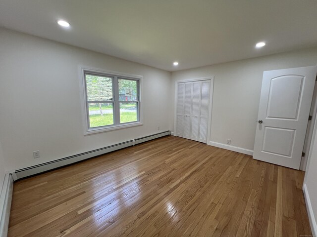 52 Sylvan St, Avon, CT 06001 - unfurnished bedroom featuring a baseboard radiator, light wood-style flooring, recessed lighting, and a closet