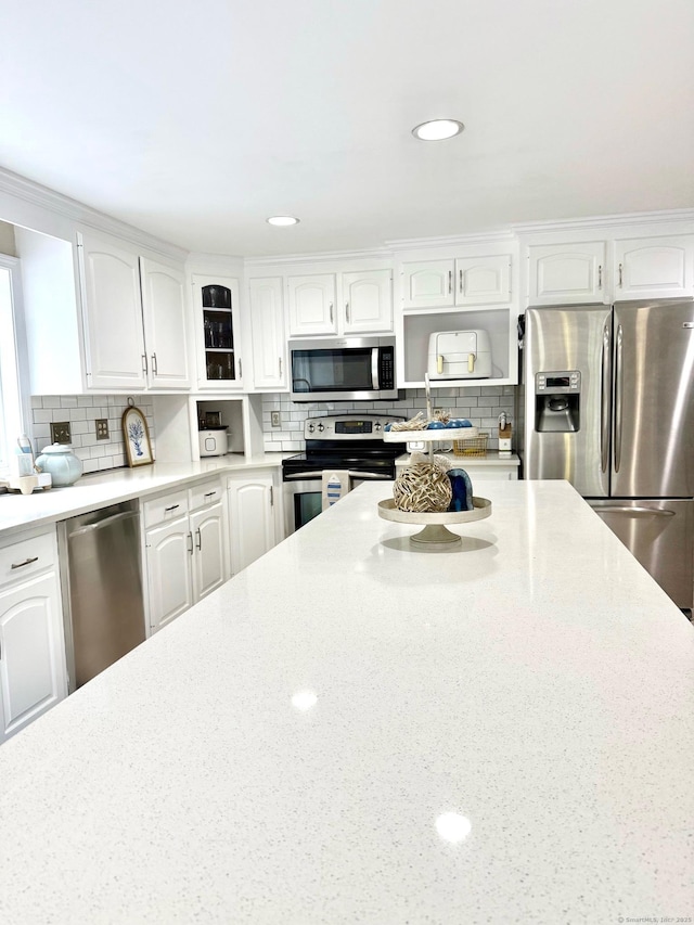 13 Charter Oak Dr, East Lyme, CT 06333 - kitchen with appliances with stainless steel finishes, decorative backsplash, white cabinets, light stone countertops, and recessed lighting