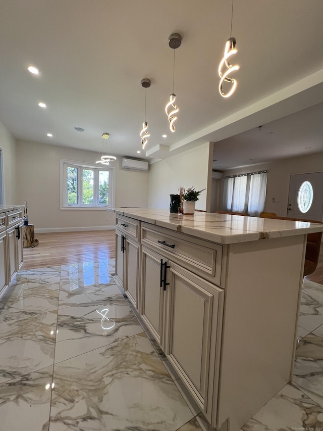 372 Oakland St, Manchester, CT 06042 - kitchen featuring an AC wall unit, light marble finish floors, recessed lighting, a center island, and light stone counters