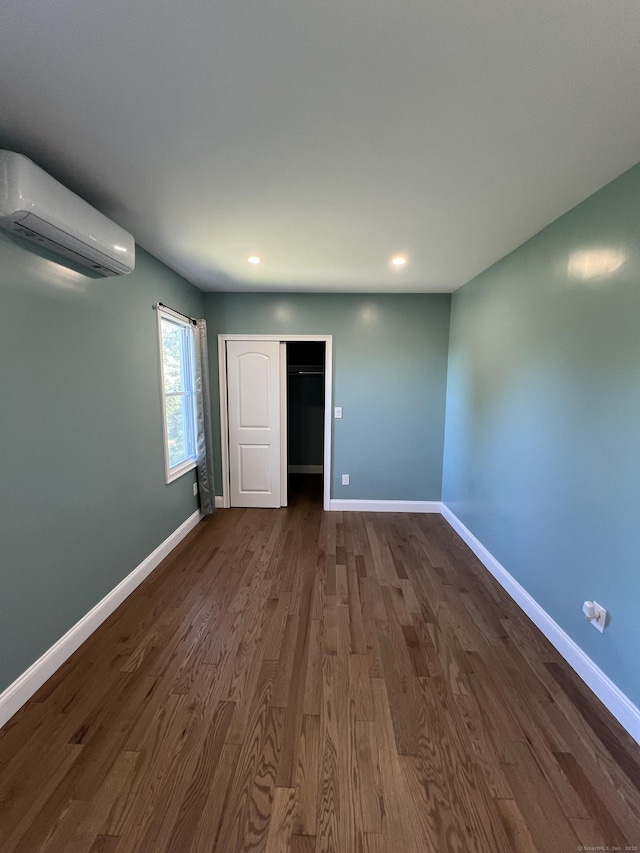 372 Oakland St, Manchester, CT 06042 - unfurnished bedroom featuring a wall mounted AC, dark wood finished floors, recessed lighting, and a closet