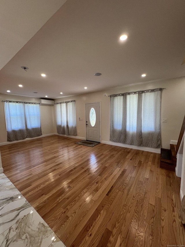 372 Oakland St, Manchester, CT 06042 - unfurnished living room featuring recessed lighting, wood finished floors, and a wall mounted air conditioner