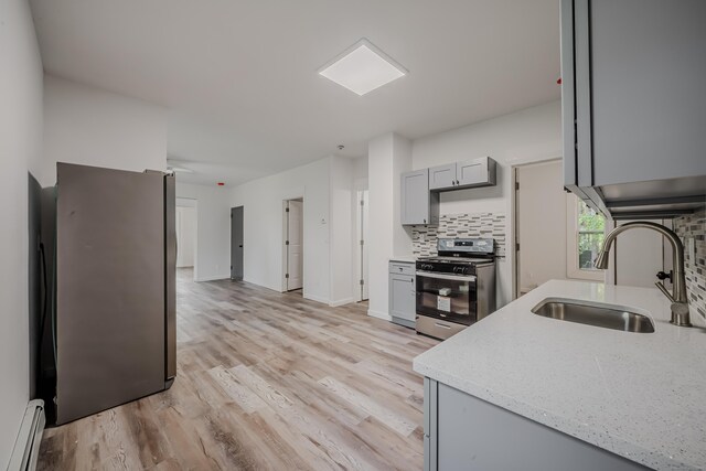 156 Waterville St, Waterbury, CT 06710 - kitchen with stainless steel gas range oven, a baseboard heating unit, gray cabinetry, decorative backsplash, and light wood-style floors