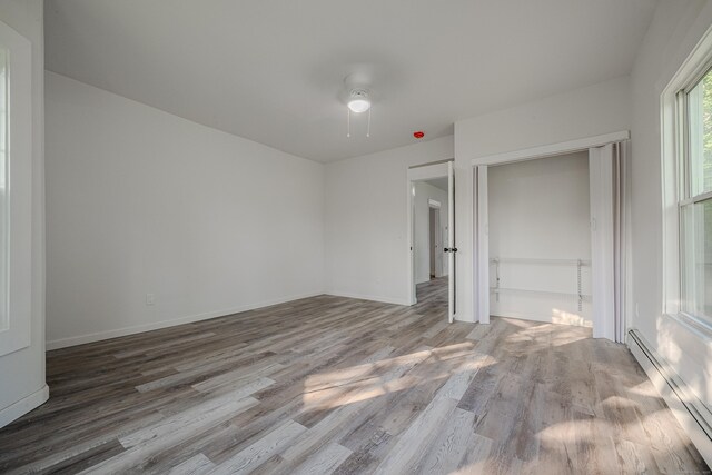 156 Waterville St, Waterbury, CT 06710 - unfurnished bedroom with a baseboard radiator, wood finished floors, and a ceiling fan