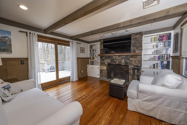 127 Skunk Misery Rd, Haddam, CT 06441 - living room featuring hardwood / wood-style flooring, a wainscoted wall, a stone fireplace, beamed ceiling, and built in shelves